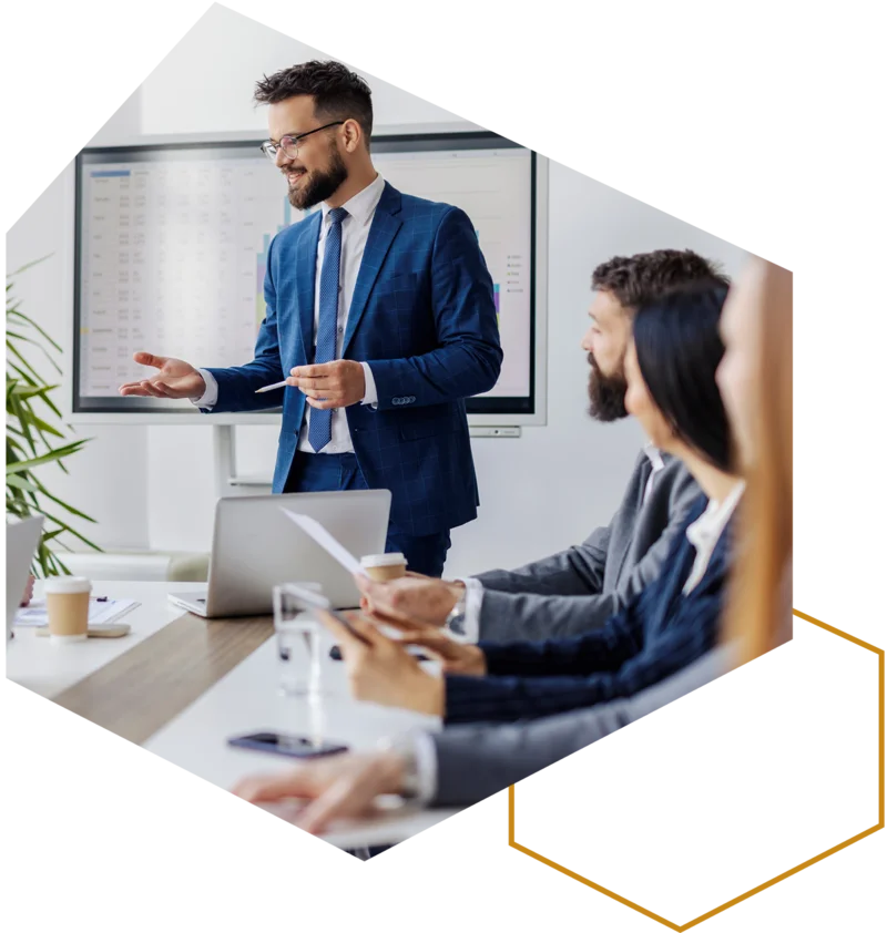 Referent erklärt Inhalte im Seminar; Teilnehmende sitzen am Konferenztisch.