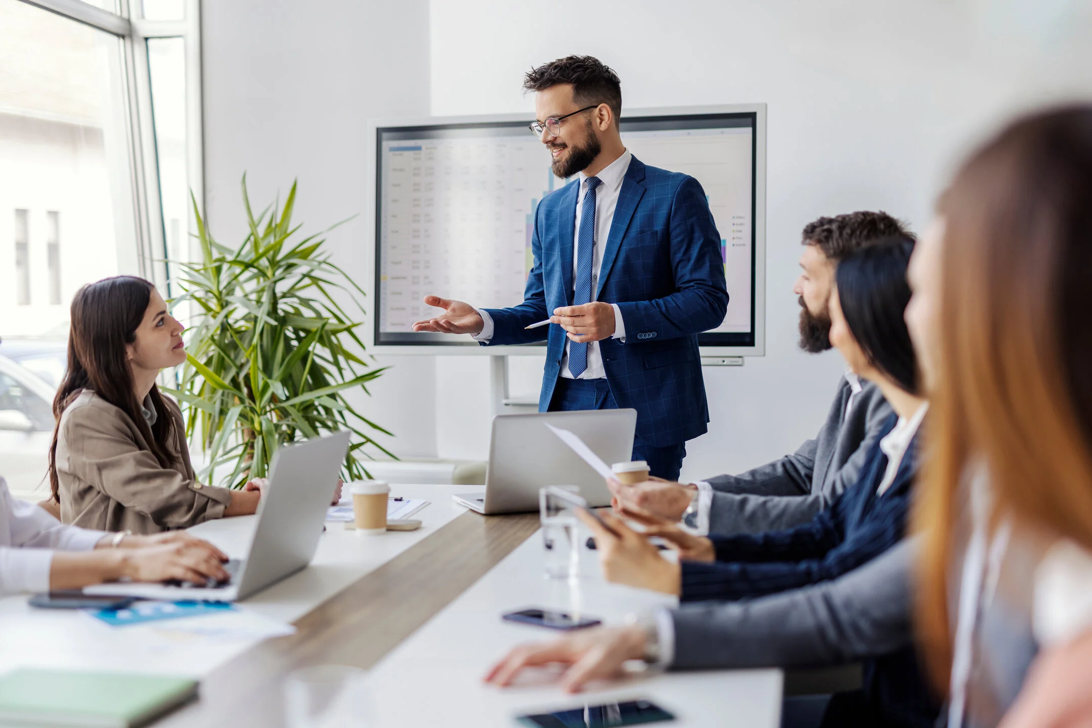 Referent erklärt Inhalte im Seminar; Teilnehmende sitzen am Konferenztisch.