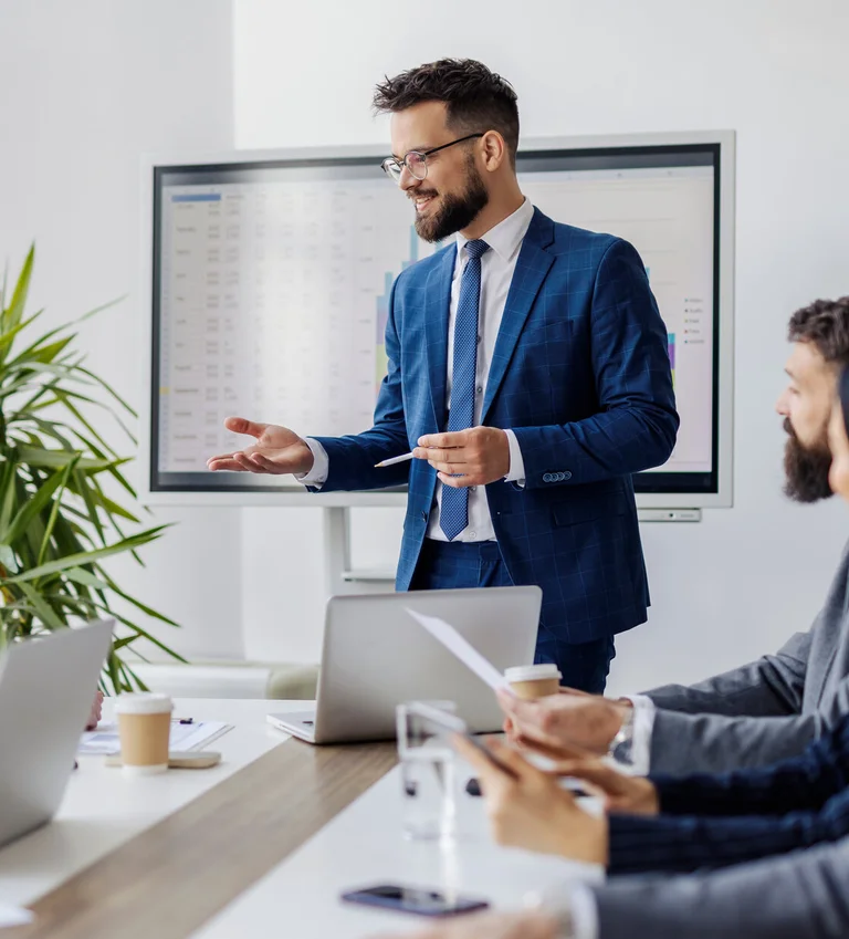 Referent erklärt Inhalte im Seminar; Teilnehmende sitzen am Konferenztisch.