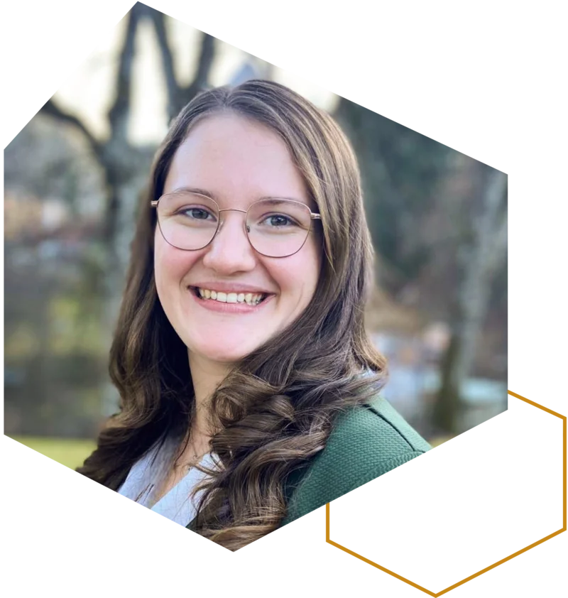 Porträt einer lächelnden Frau mit Brille im Freien.