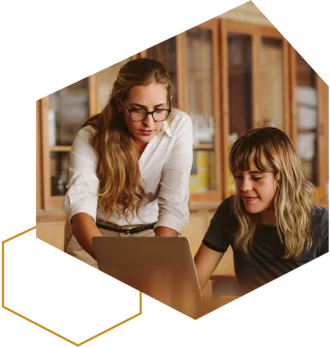 Zwei Frauen arbeiten gemeinsam am Laptop und besprechen Inhalte.