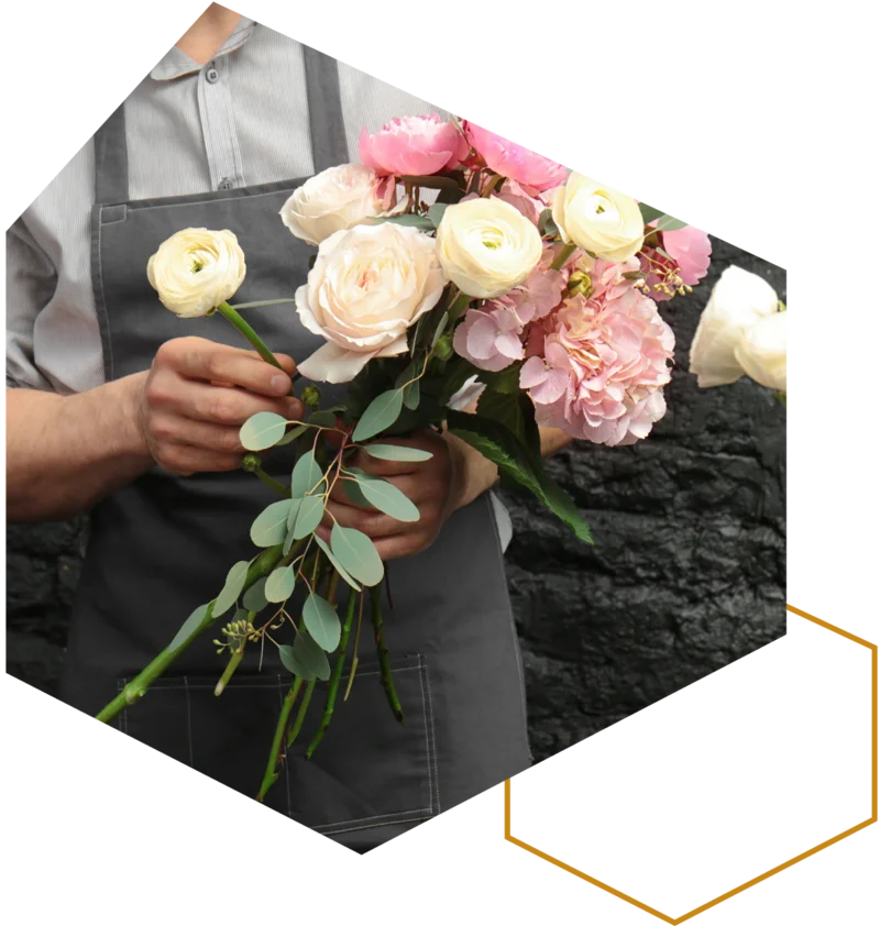 Hände halten einen gebundenen Blumenstrauß.