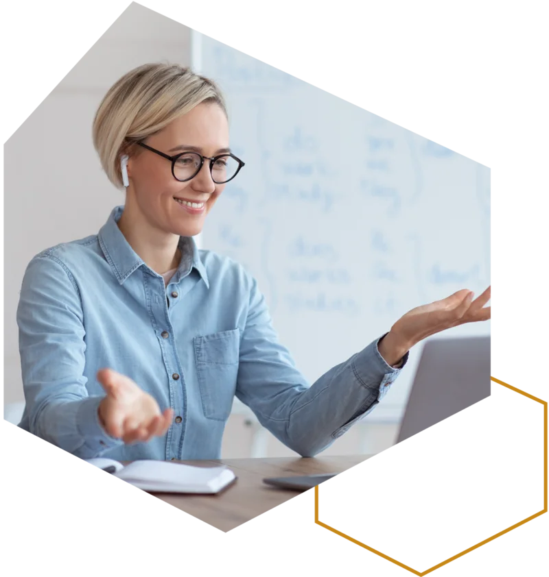 Frau mit Brille erklärt etwas gestikulierend vor einem Whiteboard.