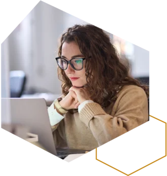 Frau mit Brille sitzt vor einem Laptop während einer Online-Schulung