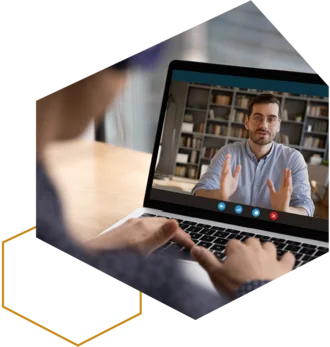 Online-Meeting am Laptop: Person spricht per Videoanruf, Hände tippen auf der Tastatur.