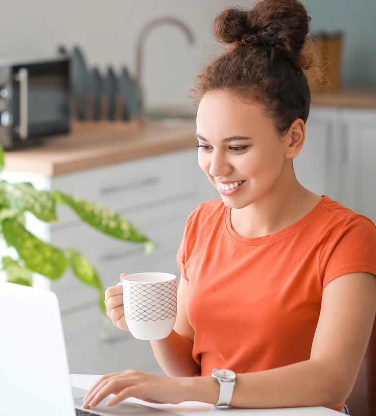 Frau arbeitet am Laptop am Schreibtisch zu Hause.