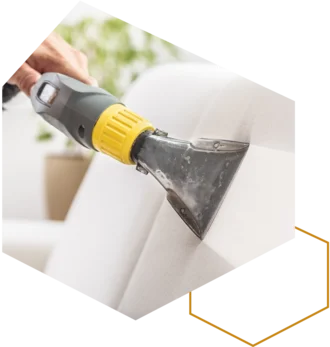 Polsterreinigung: Hand führt einen Nasssauger über einen Stuhl.